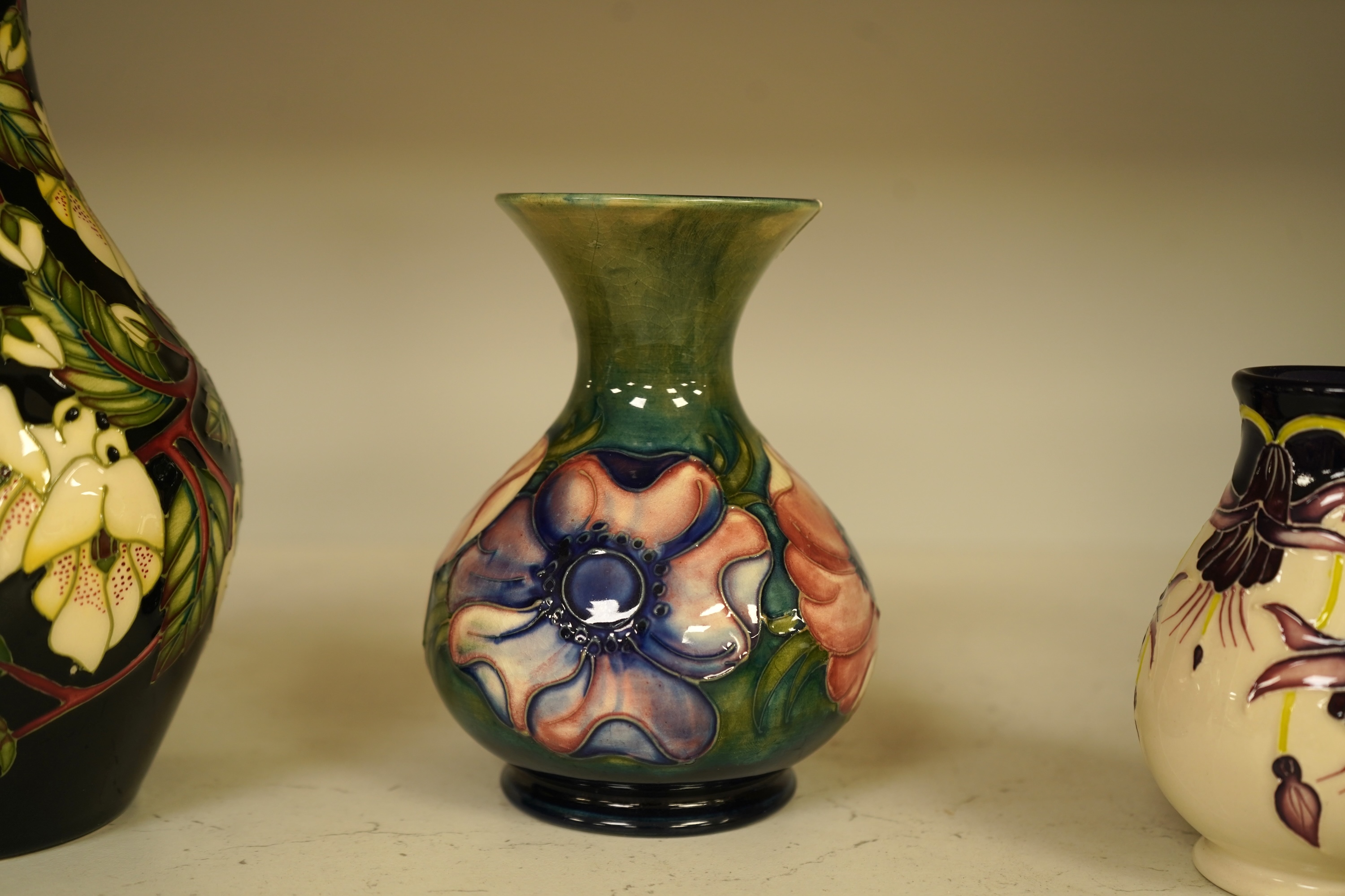 A collection of modern Moorcroft to include a mountain gold pattern vase, two pin dishes and a Hibiscus pattern candlestick, largest 20cm high